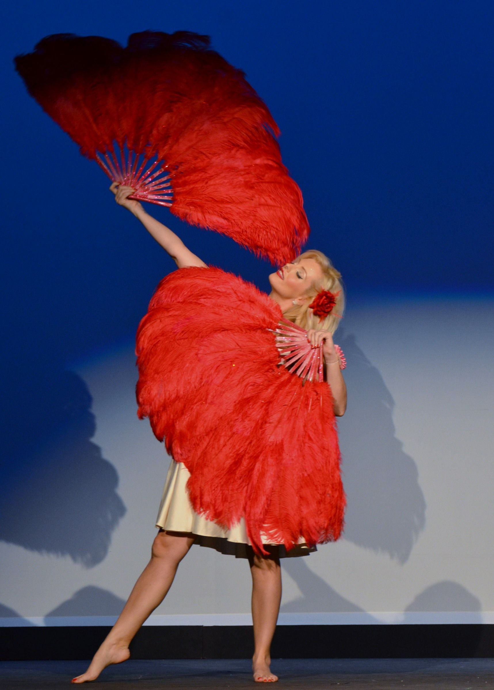 feathered kisses act dancing with large red feather hand fans